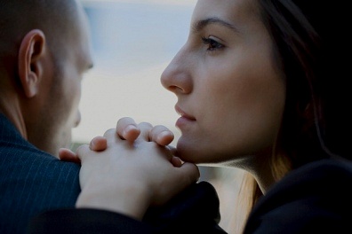 woman with her hand and chin on a man shoulder